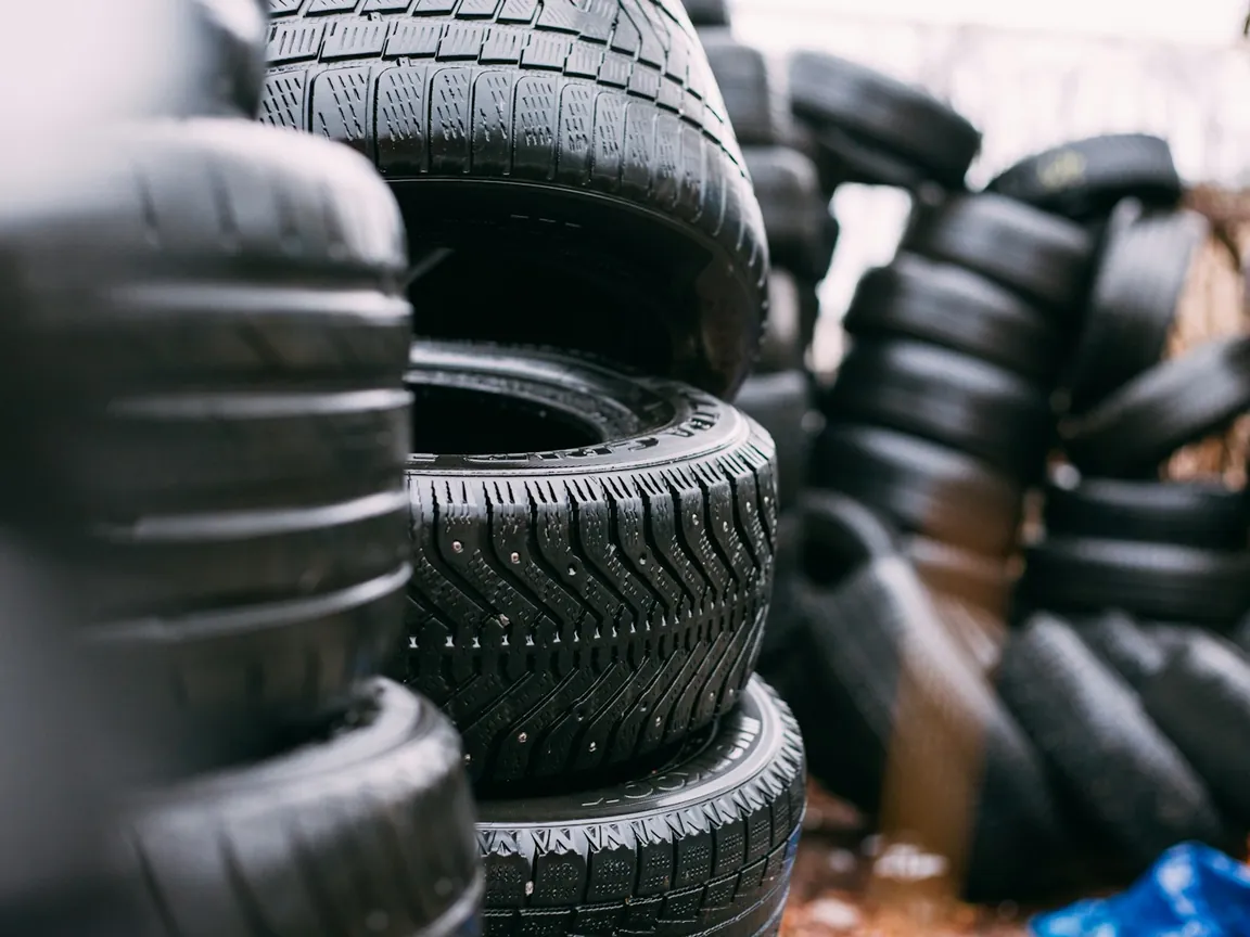 Stacks of used car tires waiting at a tire shop